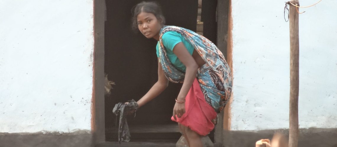 Women cleaning her mud house-min